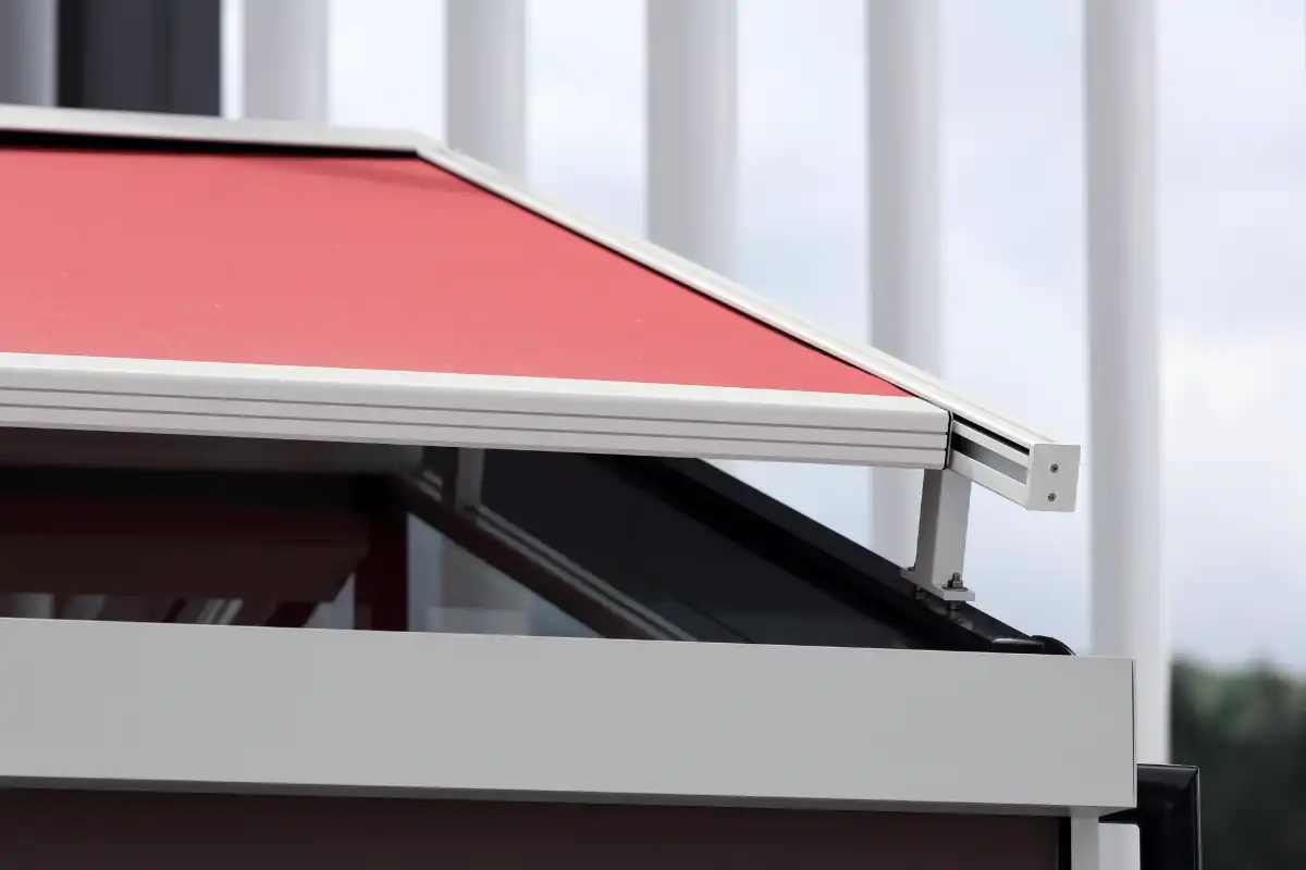 Rote Wintergarten-Markise für einen modernen Wintergarten Rotes Sonnenschirmdach über einem modernen Gebäude