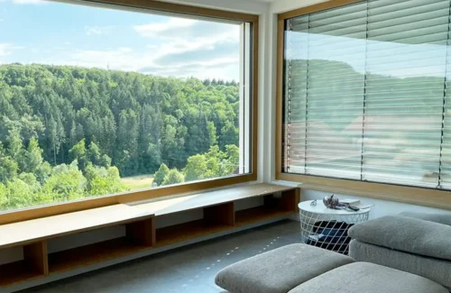 Blick durch ein großes Fenster in den Wald